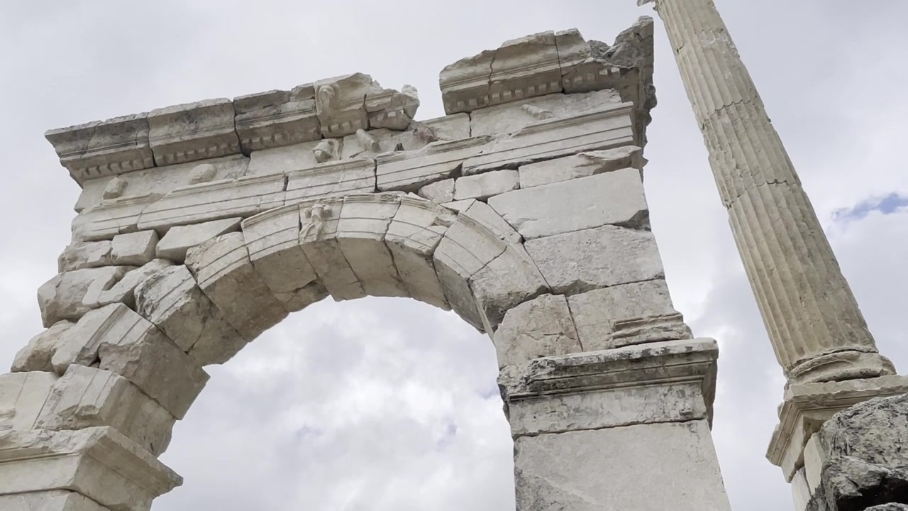 Arco monumentale in pietra e colonna eretta nell'antica città di Sagalassos, Turchia. Architettura romana classica