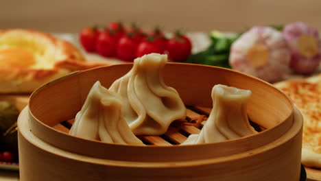 steamed khinkali in a bamboo steamer basket