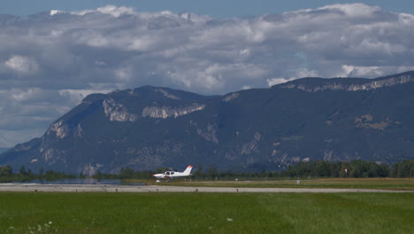 small propeller plane taxiing before mountains