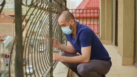 depressed man on balcony of his apartment