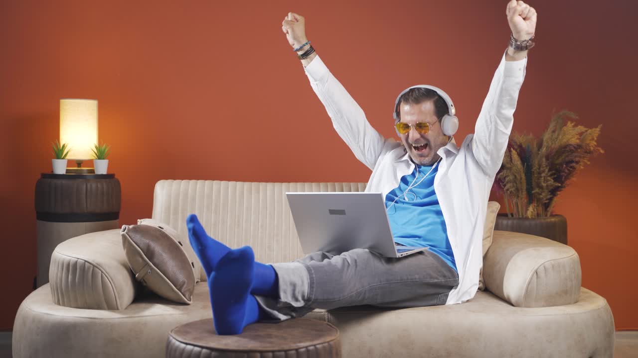 el hombre mira la computadora portátil y se alegra.