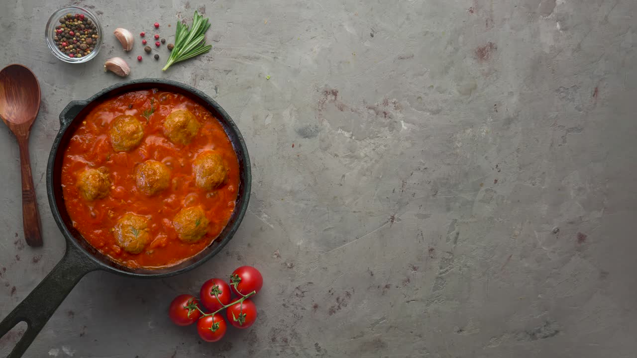 cocinar albóndigas con salsa de tomate en una sartén negra. colocación plana, vista superior con espacio de copia