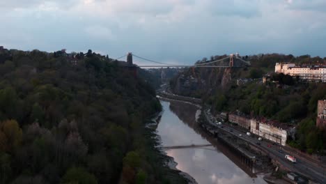 Drone-shot-along-river-Avon-Hotwell-road-towards-Clifton-suspension-bridge-Bristol-at-sunset