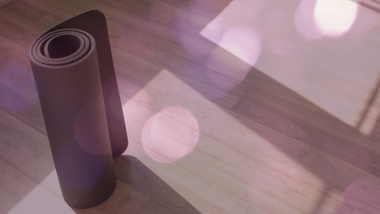 alfombra de yoga enrollada en el suelo de madera con animación bokeh ligera