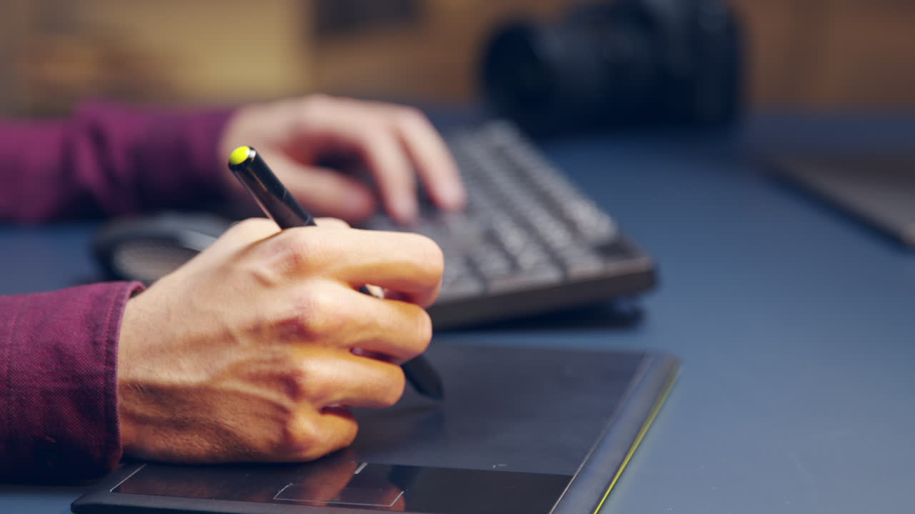 diseñador gráfico de primer plano que utiliza una tableta para el retoque creativo