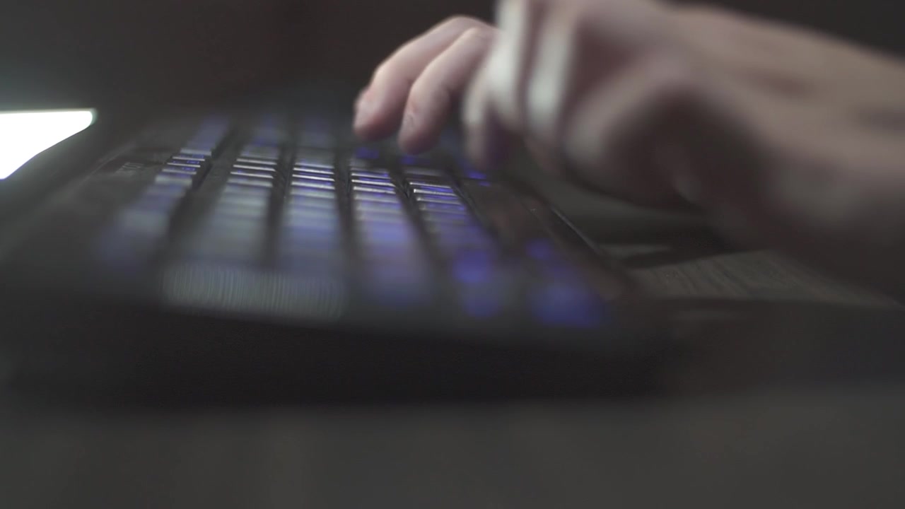 a rack focus of a person typing on a keyboard.
