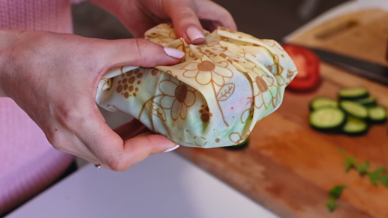 Woman hands demonstrating a healthy sandwich in beeswax food wrap