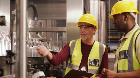 Workers-checking-bottles-on-production-line