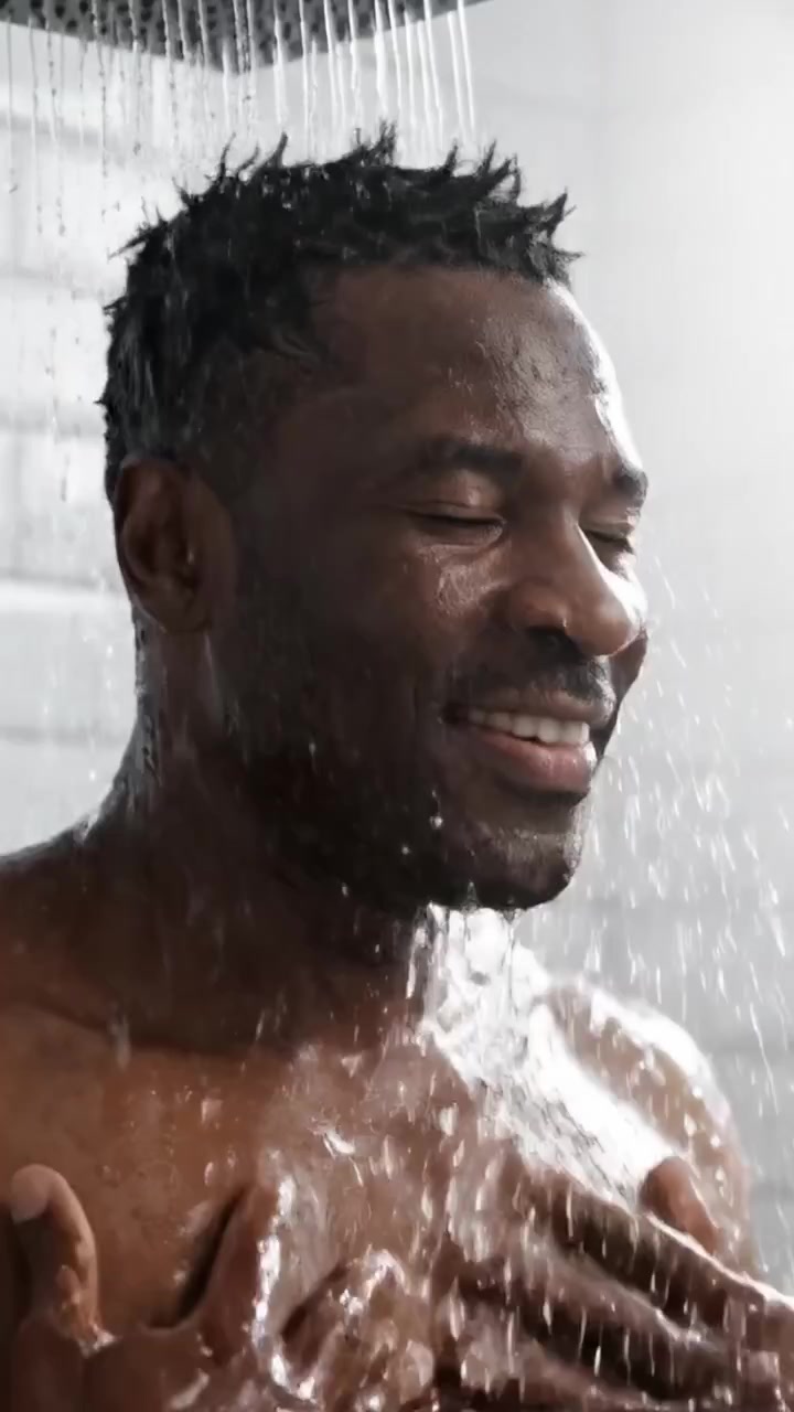 A Relaxing Shower Experience Captured in Frames: A Man Enjoys the Refreshing Water as He Cleanses and Refreshes His Body Under a Invigorating Stream