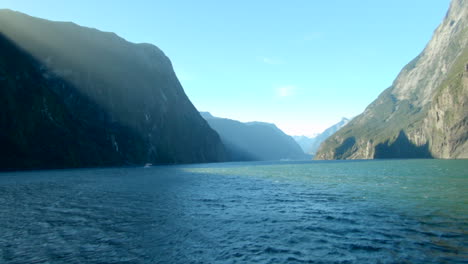 sunbeams over the cliffs of milford sound in new zealand