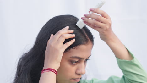 in white background a young lady using derma stamp on alopecia head to improve hair regrowth, collagen induction therapy, hairloss.