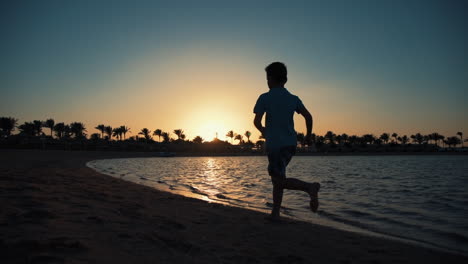 joven atractivo corriendo en la costa. niño deportivo corriendo a lo largo de la costa
