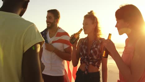 Young-adult-friends-drinking-on-a-beach-at-sunset-4k