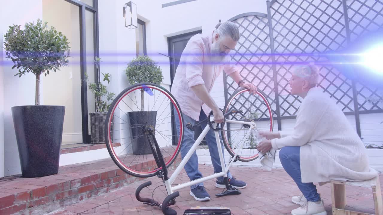 Man and woman DIY fixing upside-down bike exchanging wrench adjusting crankset preparing remount