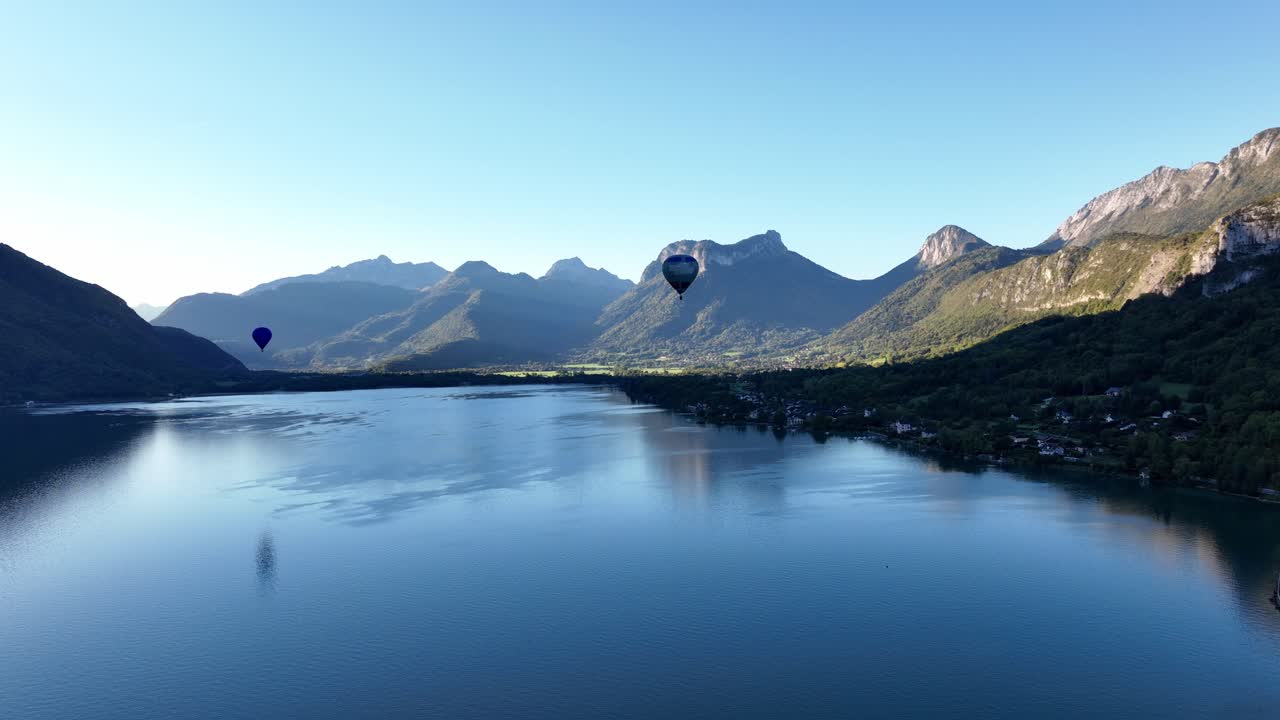 프랑스 안시 호수 위를 낮게 날고 있는 열기구