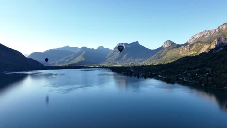 Hot-air-balloons-flying-low-over-Annecy-Lake,-France