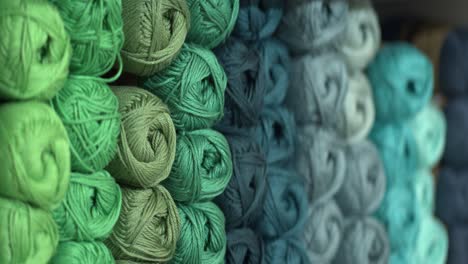 Bright-green-and-blue-knitting-yarn-packed-together-on-store-shelf