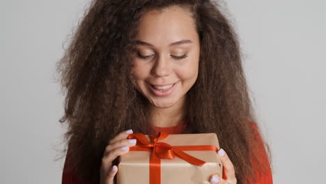 Glückliche-Kaukasische-Lockige-Frau-Mit-Einem-Geschenk.