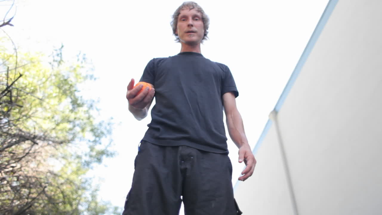 un hombre hace trucos haciendo malabarismos con una pelota con los pies