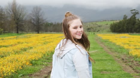 Following-young-girl-walking-in-countryside-wilderness-as-she-looks-back-at-camera-slow-motion