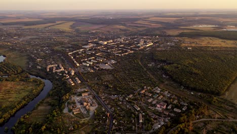 aerial footage over small town in nature. flight over the small buildings among fields in summer. aerial view.
