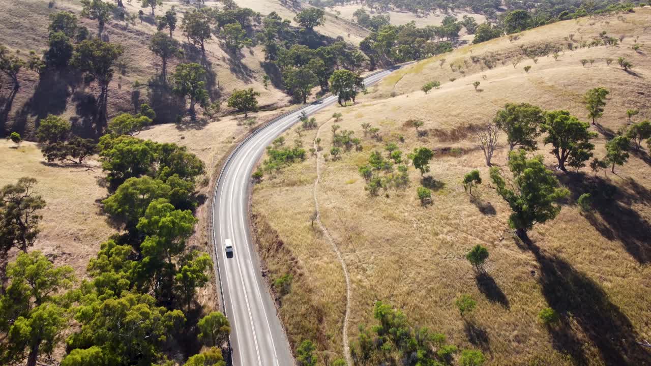 플린더스의 공중 드론 뷰 팬은 로드 힐 애들레이드 포트 오거스타 사우스 오스트레일리아 4k에 도로 부시랜드 나무에 밴이 있는 산들을 범위