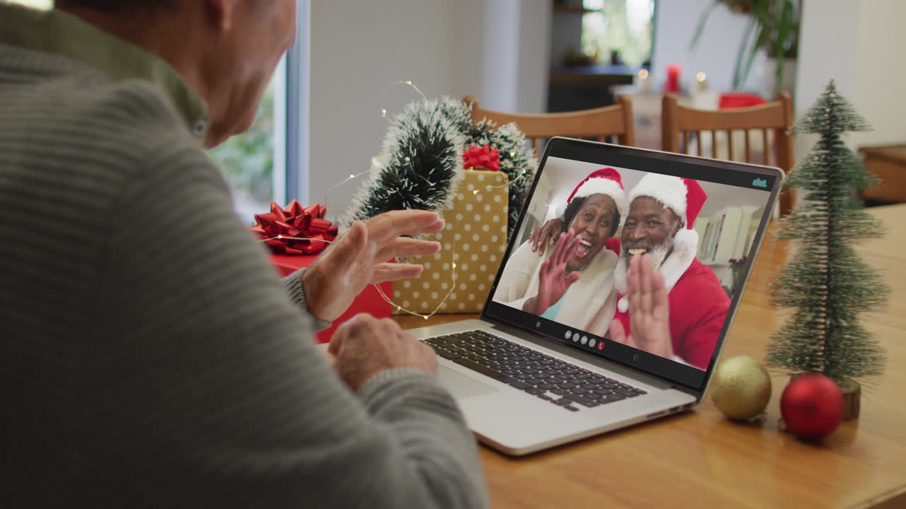 hombre mayor caucásico feliz en videollamada con amigos mayores en tiempo de navidad