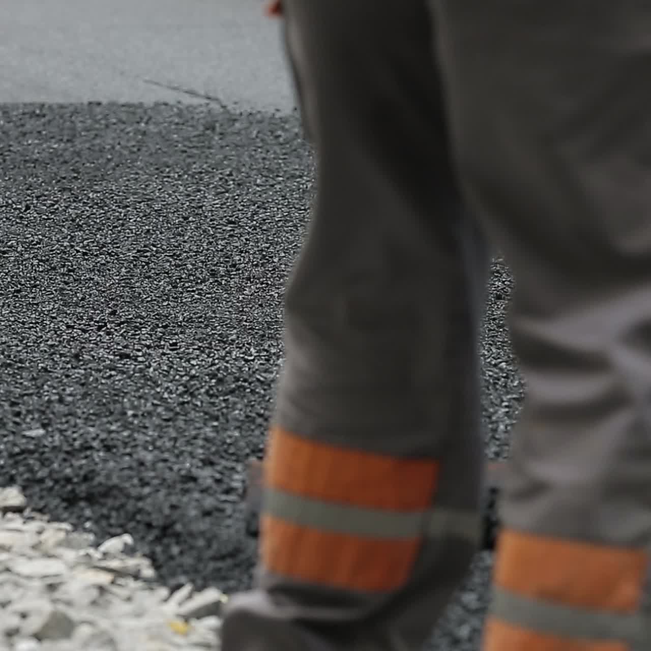 Worker Leveling Fresh Asphalt
