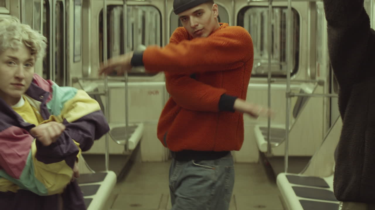 Crew di ballerini in streetwear alla moda che ballano in metropolitana.