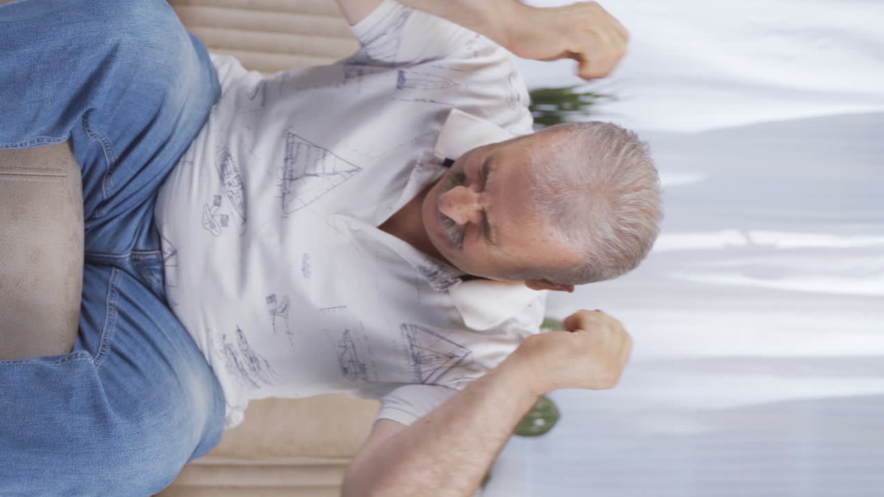 신경 ⁇ 약을  ⁇ 고 있는 노인의 수직 비디오는 화가 나고 기분이 좋지 않습니다.