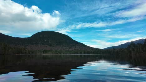 still lake view reflects mountain and clouds in vibrant light, new hampshire setting