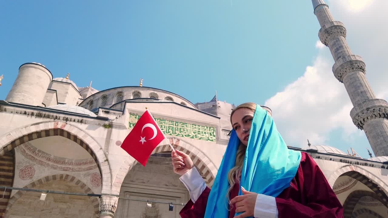 câmera lenta: garota bonita e atraente em camisa acena bandeira turca com vista da mesquita do sultão ahmet em istambul, turquia