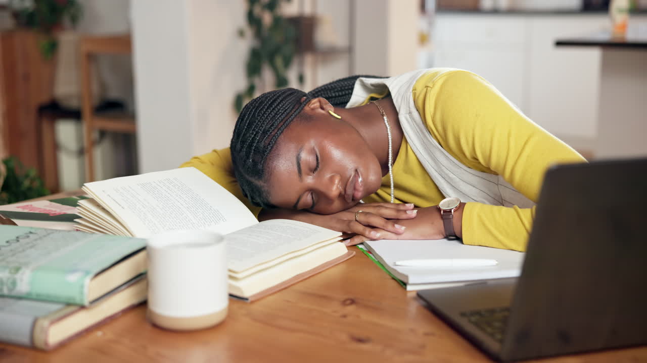 Sliten student som sover ved pulten