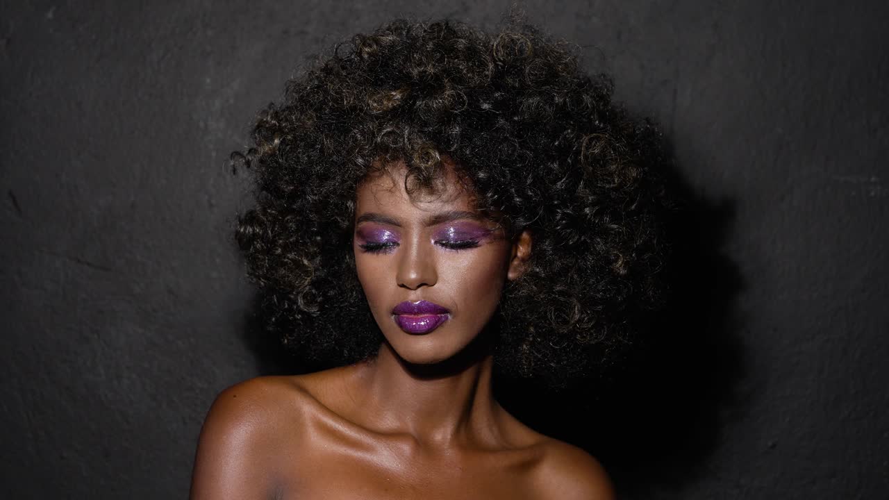mujer negra elegante con afro y maquillaje