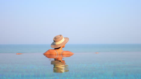 Mujer-Irreconocible-En-La-Piscina-Disfrutando-De-La-Vista-Al-Mar,-Copiando-Espacio