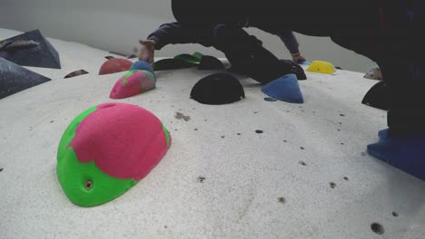 Close-up-of-an-indoor-climbing-gym-wall-full-of-different-colour-holds-seen-from-below