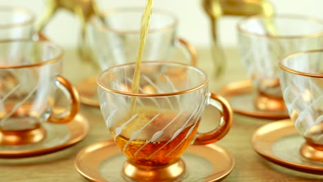 Captures-a-delightful-scene-of-a-transparent-teapot-gracefully-pouring-freshly-brewed-tea-into-a-glass