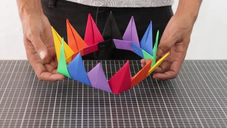 hands showing colorful rainbow paper handmade crown, crafting