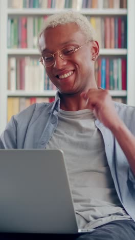 young overjoyed african american man looks at laptop and makes victory gesture