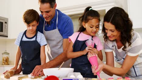 Happy-family-preparing-cookies-in-kitchen