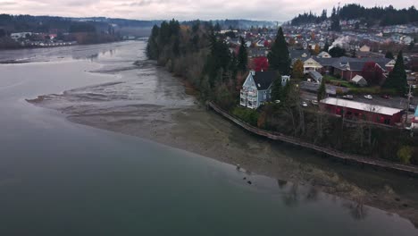 Orbiting-drone-shot-of-a-waterfront-house-in-the-early-morning-near-Seattle