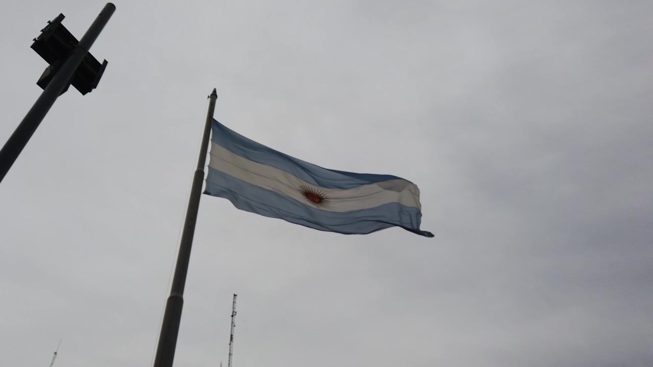 Vue en contre-plongée d'un drapeau argentin flottant au-dessus d'un horizon nuageux.