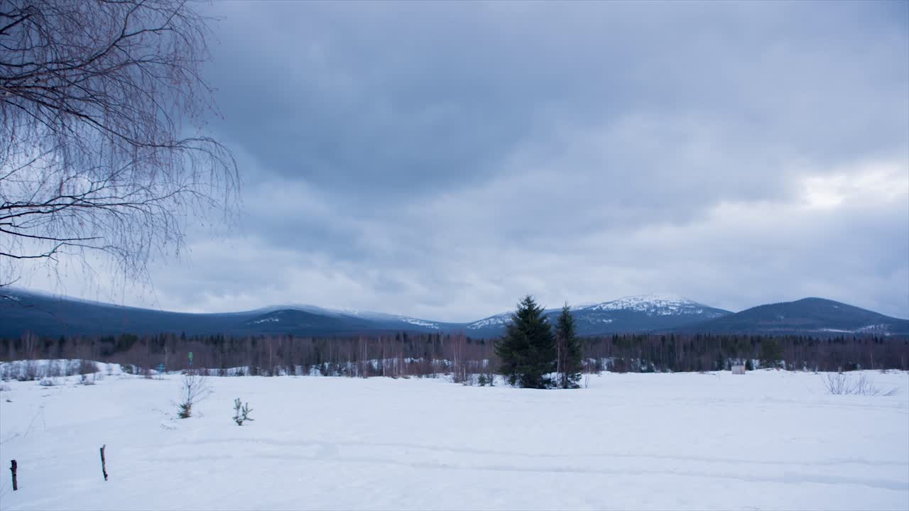 구름이 가득한 하늘 아래의 눈 인 산악 풍경