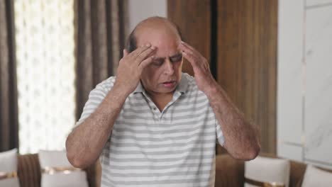 fat indian old man having headache