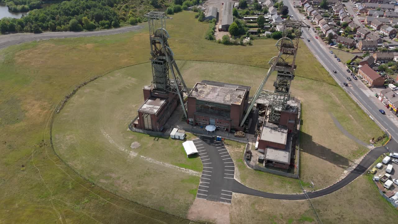 Drone aerial cinematic footage of industrial coal mine headstocks and raw material heritage site near Nottingham England UK