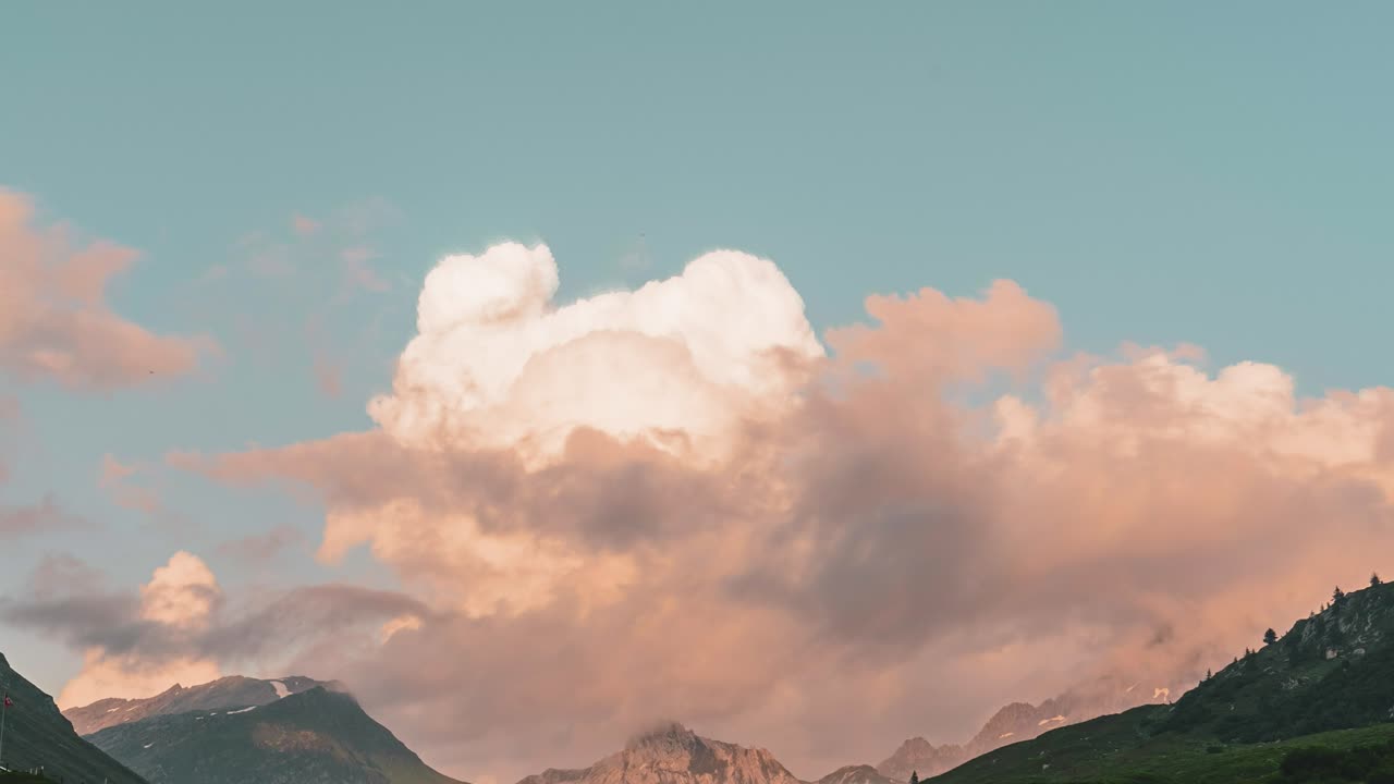This timelapse video, transitions from dramatic close-up to a wide view. It captures a storm cloud turning over the rugged mountains near Lake Cadagno, Ticino, Switzerland.