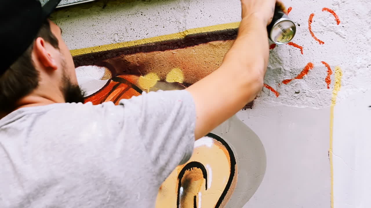 Kunstneren tegner graffiti på et gjerde. Abstrakt tegning.