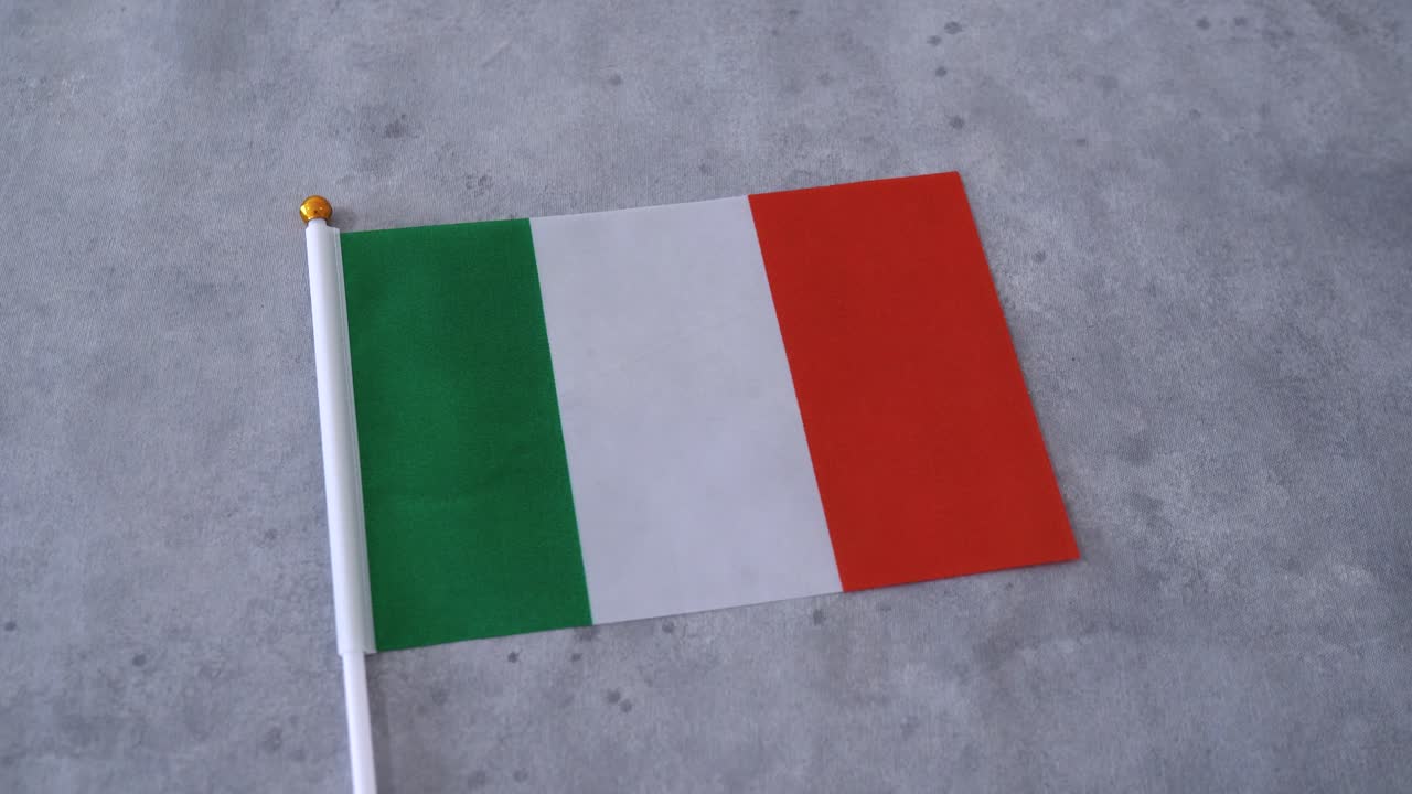 Bandiera italiana in primo piano su sfondo grigio. Bandiera nazionale italiana.