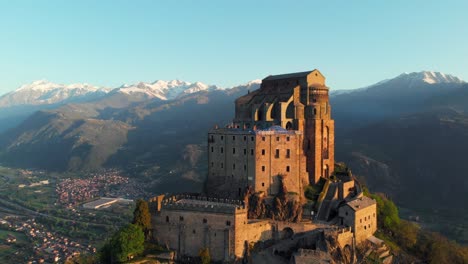 aerial: drone flying at old medieval abbey perched on mountain top - turin, italy