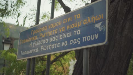 Primer-Plano-De-Un-Cartel-En-Griego-Presentando-El-Casco-Antiguo-De-Leonidio,-Grecia